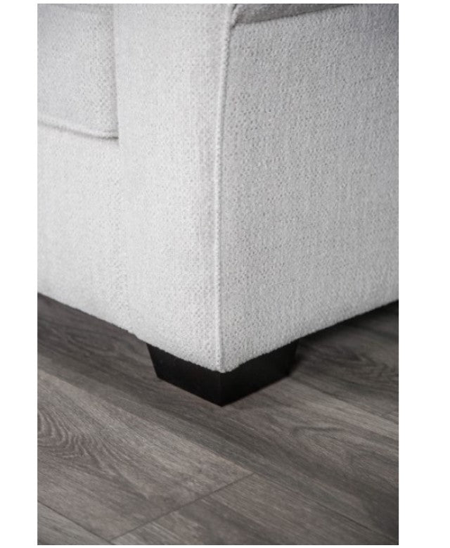 Kumar Rolled Arm White Fabric Sofa White sofa with patterned cushions in a living room with large windows.