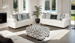 Kumar Rolled Arm White Fabric Sofa Living room with white sofas, patterned ottoman, and decorative pillows.