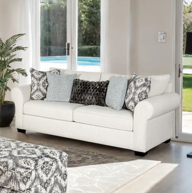 Kumar Rolled Arm White Fabric Sofa White sofa with patterned cushions in a living room with large windows.