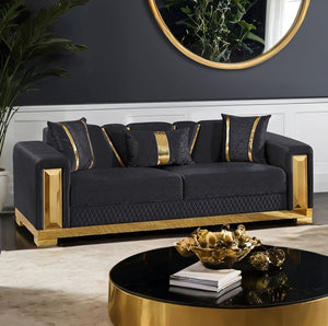 Lika Glam Black Sofa Gold Trims Modern living room with a black sofa and gold accents, featuring a round mirror and decorative items.