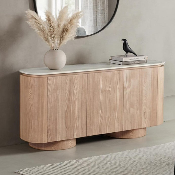 Limda Natural Sintered Stone Top Round Edges Server Wooden sideboard with a vase of pampas grass and decorative books against a neutral wall.