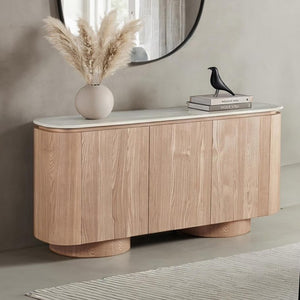 Limda Natural Sintered Stone Top Round Edges Server Wooden sideboard with a vase of pampas grass and decorative books against a neutral wall.
