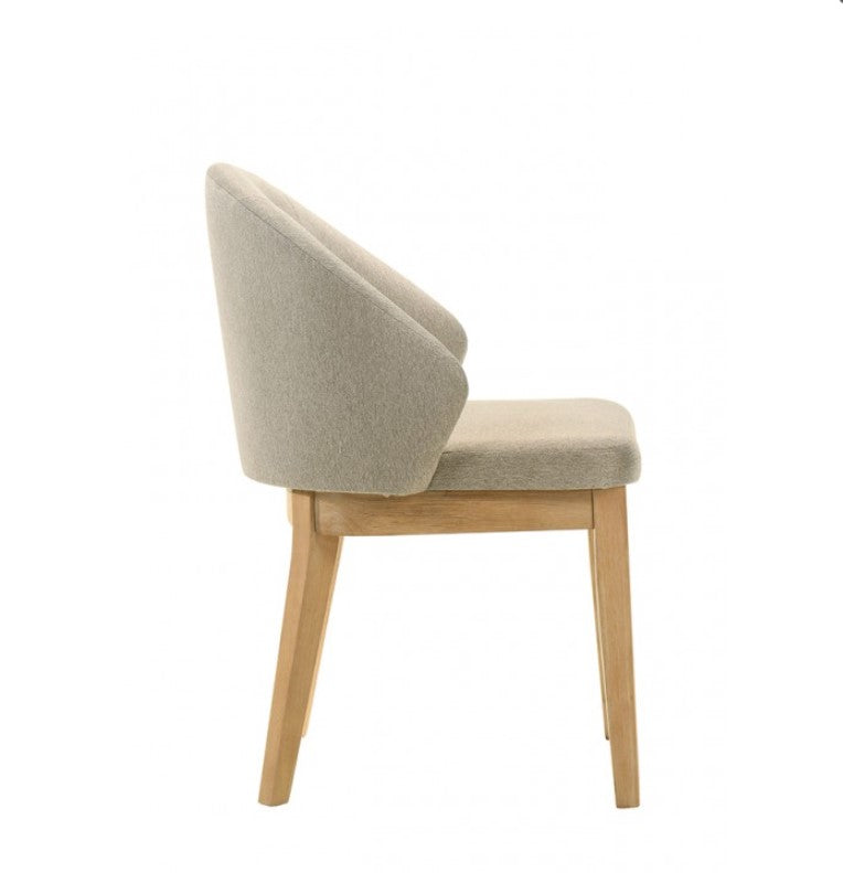 Maeve Organic Modern Oak Finish Dining Chair Dining chair with wooden legs and gray cushioned seat and backrest in a room with a wooden table.