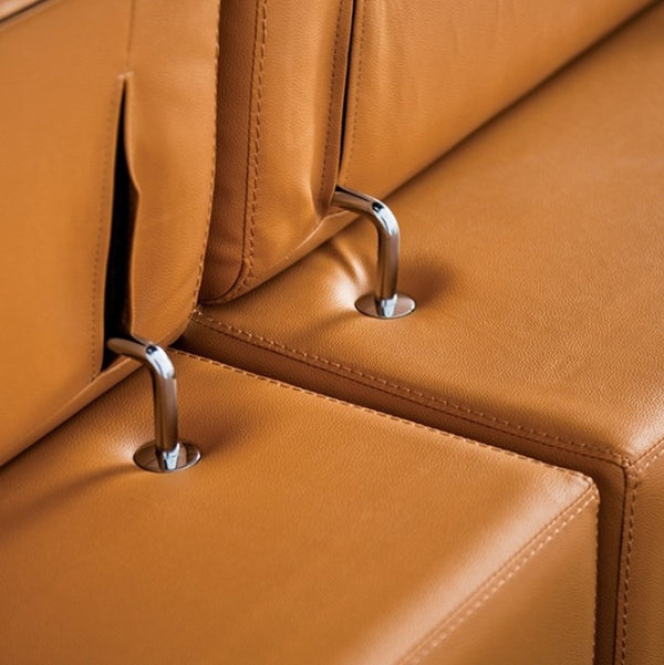 Matteo Modern Style Tangerine Adjustable Headrest Leather Sectional Sofa Close-up of a brown leather chair with metal legs.