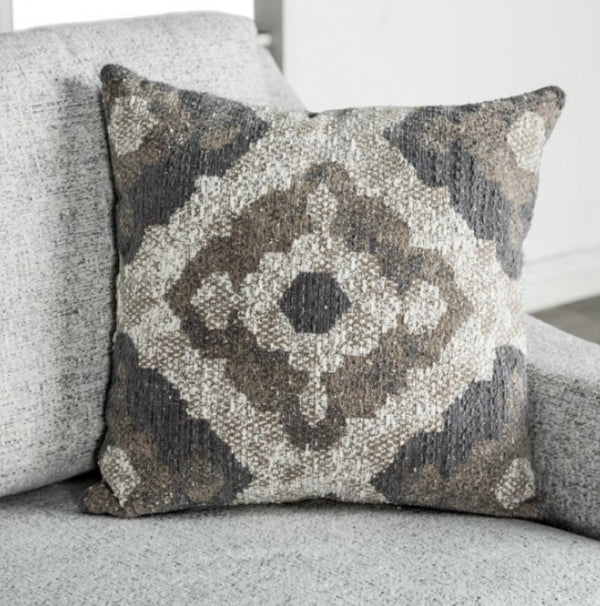 Decorative pillow with a geometric pattern on a gray sofa