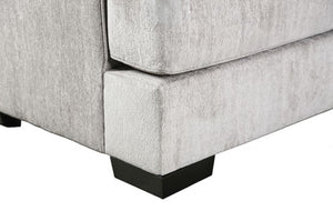 Close-up of a gray upholstered chair corner with a white background