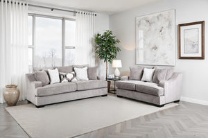 Mika Oversized Transitional Style Sofa Set Gray sectional sofa in a living room with large windows and decorative elements.