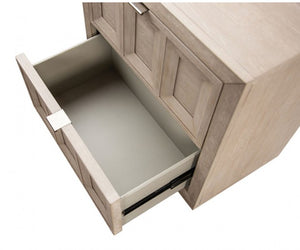 Montague Cross Modern Classic Tawny Credenza A close-up of a light wood drawer pulled open, showing a smooth light gray interior and a silver drawer pull handle on a white background.