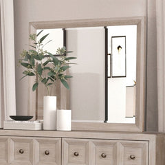 Montague Cross Modern Classic Tawny Mirror A large rectangular wall mirror with a light natural wood frame, mounted above a matching light wood dresser. The scene is styled with white vases, a black bowl, and a green plant on the dresser, set against a neutral beige wall and curtains.