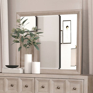 Montague Cross Modern Classic Tawny Mirror A large rectangular wall mirror with a light natural wood frame, mounted above a matching light wood dresser. The scene is styled with white vases, a black bowl, and a green plant on the dresser, set against a neutral beige wall and curtains.