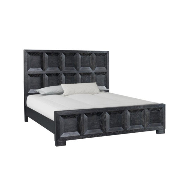 Montague Cross Modern Classic Weathered Black Bed A dark gray wooden bed frame with a high, geometrically paneled headboard and matching footboard, shown with white bedding and two pillows on a solid white background.