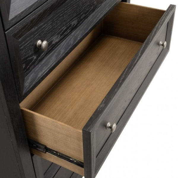 Montague Cross Modern Classic Weathered Black Chest A close-up of a dark wood dresser drawer pulled open, showing a light natural wood interior and silver round drawer knobs against a white background.
