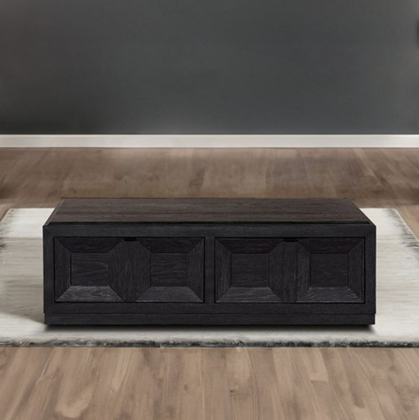 Montague Cross Modern Style Weathered Black Coffee Table A dark wood storage bench with two geometric panel-front drawers, placed on a light rug over a wood floor against a dark gray wall.