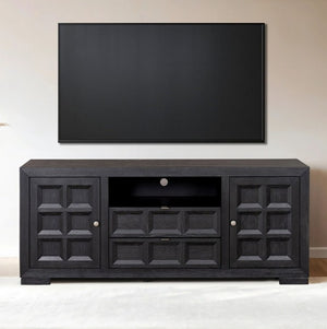 Montague Cross Modern Style Black TV Stand 72" A black wooden TV stand with decorative paneled doors and a central open shelf, shown against a beige wall with a large black television mounted above it.
