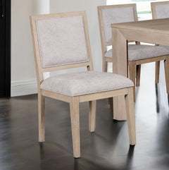 Montague Cross Modern Style Dining Chair A light wood dining chair with a beige upholstered seat and backrest, shown in a dining room setting next to a matching wooden table.
