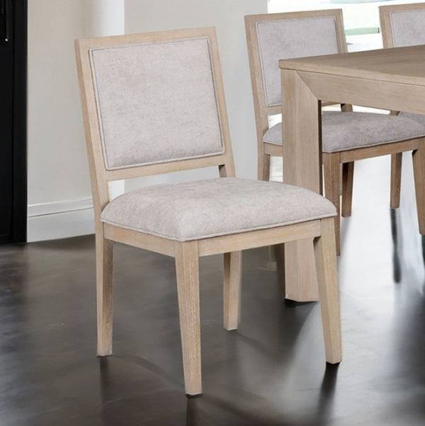 Montague Cross Modern Style Dining Chair A light wood dining chair with a beige upholstered seat and backrest, shown in a dining room setting next to a matching wooden table.