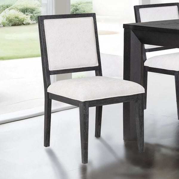 Montague Cross Modern Style Weathered Black Dining Chair Dining chair with white cushioned seat and backrest in a room with a table and window.
