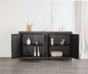 Montague Cross Modern Style Weathered Black Dining Server A modern black wooden sideboard cabinet with two open doors, styled with decorative vases, candles, and a basket on a light gray wood floor against a white wall.