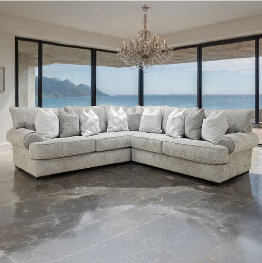 Nareen Gray Fabric Sectional Sofa with Pillows Gray sectional sofa with white pillows in a room with large windows overlooking an ocean view.