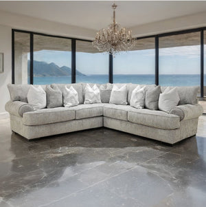 Nareen Gray Fabric Sectional Sofa with Pillows Gray sectional sofa with white pillows in a room with large windows overlooking an ocean view.