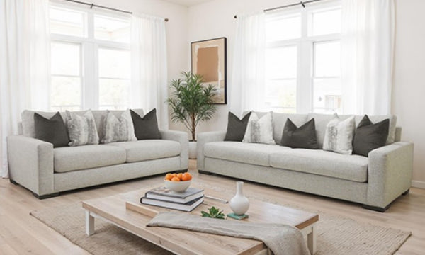 Living room with two light gray sofas, a coffee table, and decorative items.