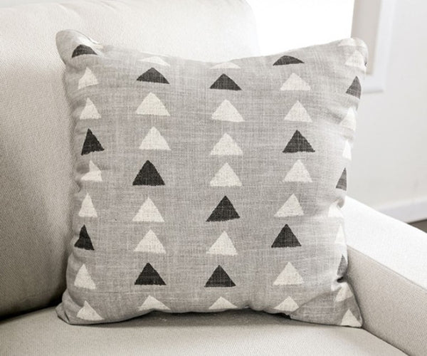 Nareen White Fabric Sectional Sofa with Multicolor Pillows Gray pillow with black and white triangle pattern on a light gray sofa.