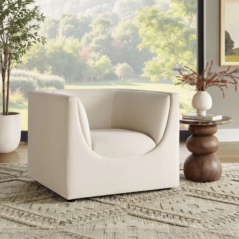 Natalia Alabaster Velvet Fabric Chair Beige armchair in a room with a large window view of greenery