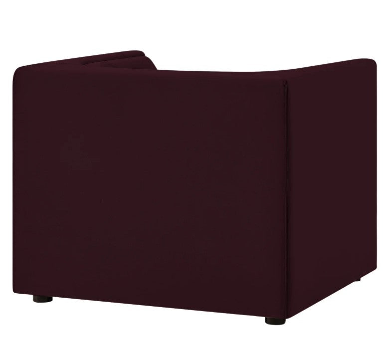 Natalia Mulberry Velvet Fabric Chair Maroon armchair in a room with a wooden side table and decorative elements.