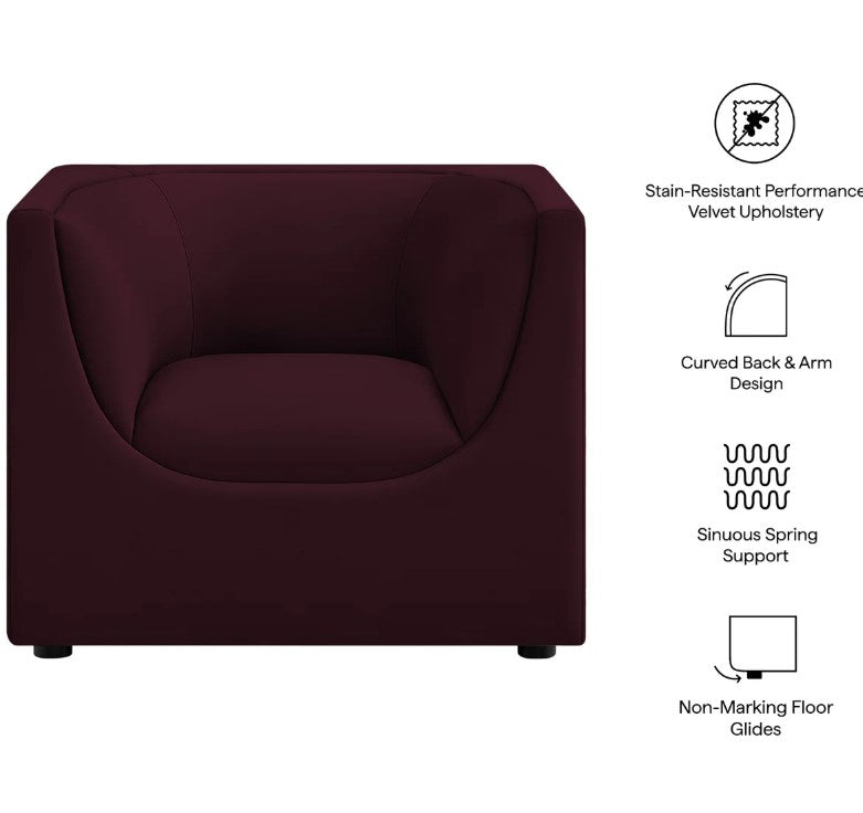Natalia Mulberry Velvet Fabric Chair Maroon armchair in a room with a wooden side table and decorative elements.