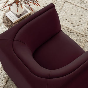 Natalia Mulberry Velvet Fabric Chair Close-up of a dark purple armchair on a textured beige rug.