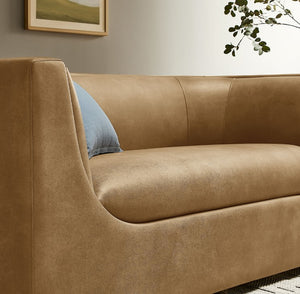 Natalia Toast Premium Vegan Leather Loveseat Brown sofa with a blue pillow in a room setting