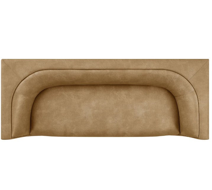 Natalia Toast Premium Vegan Leather Sofa Beige sofa in a living room with a painting on the wall and a plant on a side table.