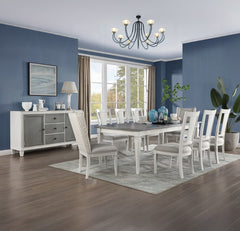 A white dining room set including a rectangular table, ten chairs, and a matching sideboard, staged in a dining room with blue walls, wood floors, and a window.
