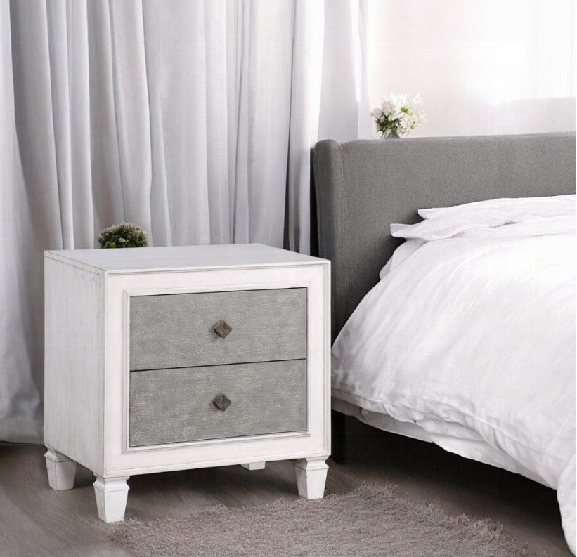 Natasha Two Tone Light Gray Nightstand A white two-drawer nightstand with textured gray drawer fronts and small dark diamond-shaped pulls, styled in a bedroom setting with a table lamp, books, and flowers on top.