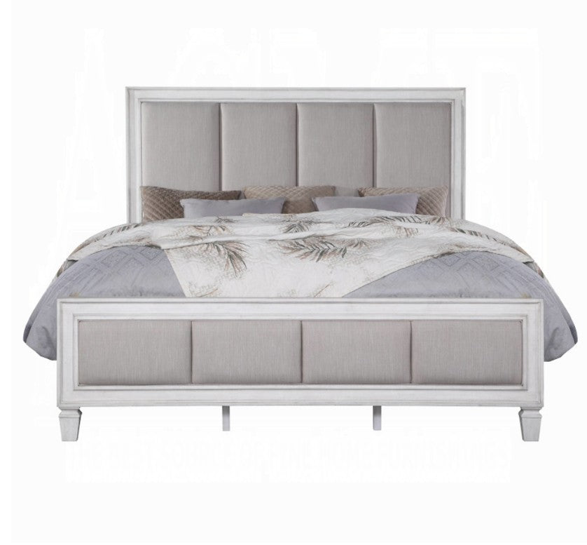 Natasha Upholstered Light Gray Linen Bedroom A bedroom furniture set in a staged room, featuring a white and gray upholstered bed frame, matching dresser, nightstand, and chest of drawers, with a gray rug and gray walls.