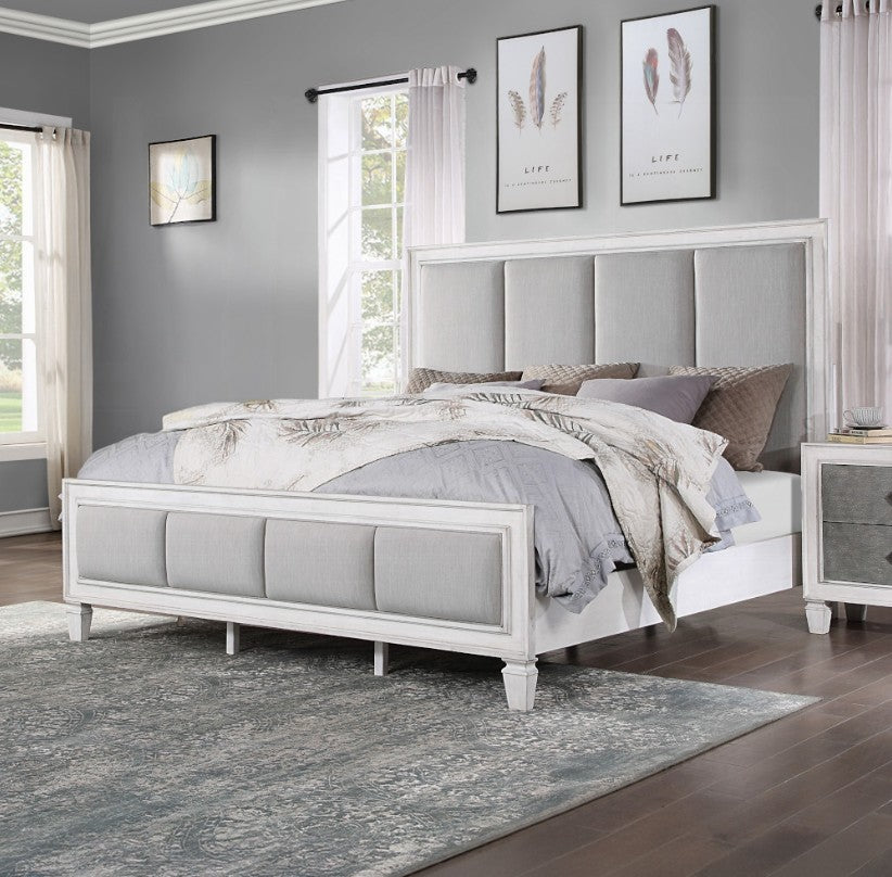 Natasha Upholstered Light Gray Linen Bedroom A bedroom furniture set in a staged room, featuring a white and gray upholstered bed frame, matching dresser, nightstand, and chest of drawers, with a gray rug and gray walls.