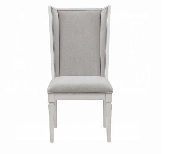 A light gray upholstered dining chair with a tall wingback backrest and a light gray painted wooden frame, shown against a plain white background.