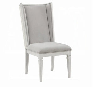 A light gray upholstered dining chair with a tall wingback backrest and a light gray frame, shown against a plain white background.