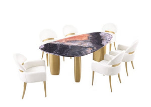 Naynem Dining Table Oval Sintered Stone Black Gray Gold Finish An oval dining table with a black and gray marbled top featuring a copper-orange center, supported by four gold cylindrical legs, surrounded by six white upholstered dining chairs with gold accents, on a solid white background.