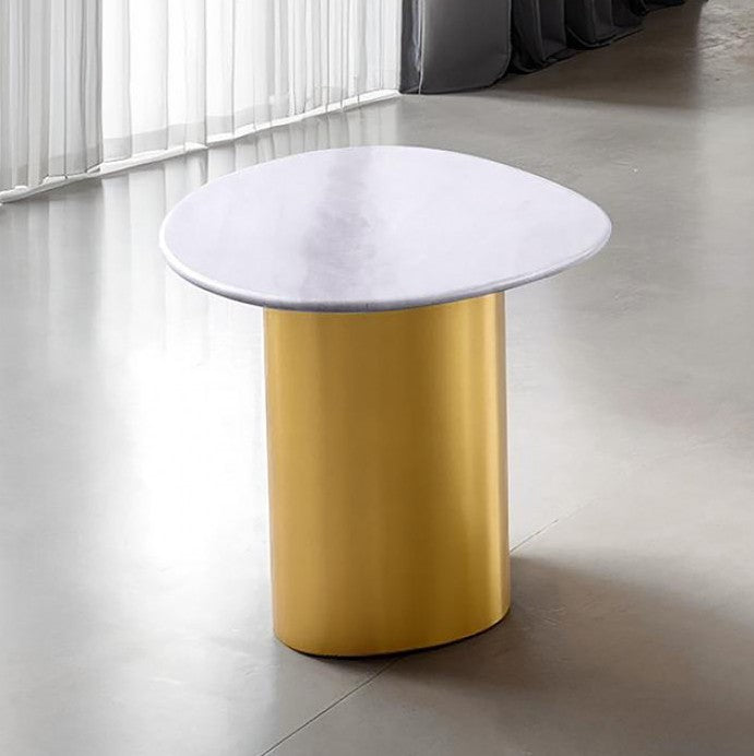 ContemporaryWhite/Matte GoldSintered Stone, Stainless SteelUnique Table Design w/ Soft Curved EdgeSintered Stone Table TopStainless Steel Legs w/ Matte A modern side table with a round white marble top and a cylindrical gold metal base, set in a minimalist interior with a concrete floor and sheer curtains.