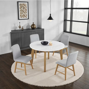 Nolan Genuine Marble Top Round Dining Table Dining room with a round white marble table and four gray chairs on a wooden floor.