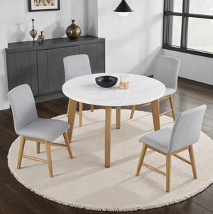 Nolan Genuine Marble Top Round Dining Table Dining room with a round white table and gray chairs on a wooden floor.