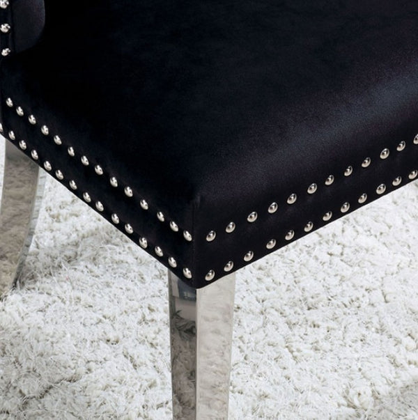 Noonwit Chrome Black Flannelette Fabric Chair (2/PK) Close-up of a black upholstered chair corner with silver nailhead trim and a metallic leg, set on a white shag rug.