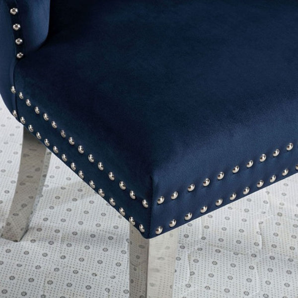 Noonwit Chrome Blue Flannelette Fabric Chair (2/PK) Close-up of a navy blue upholstered chair corner with silver nailhead trim and light wood legs on a patterned floor.