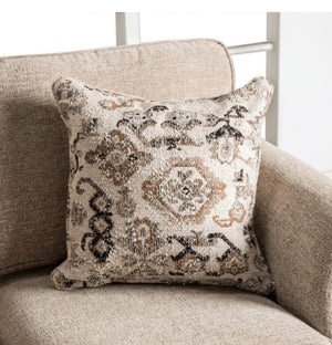 Decorative pillow with intricate patterns on a beige sofa