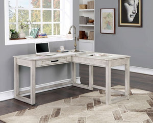 Prigala Antique White L-Shaped Corner Desk with USB Power Outlet An L-shaped corner desk in a distressed white or light gray wood finish, styled in a home office setting with a laptop, lamp, and shelving in the background.