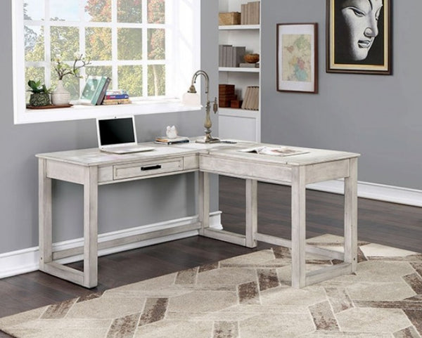 Prigala Antique White L-Shaped Corner Desk with USB Power Outlet An L-shaped corner desk in a distressed white or light gray wood finish, styled in a home office setting with a laptop, lamp, and shelving in the background.