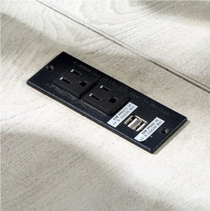 Prigala Antique White L-Shaped Corner Desk with USB Power Outlet Black electrical outlet panel with two sockets and a USB port on a light wooden surface.