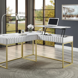 Primberg Antique White Two Tone Corner Desk An L-shaped computer desk with a white marble-patterned top and gold-finished metal legs, shown in a modern home office setting with a laptop on the raised upper desk surface.