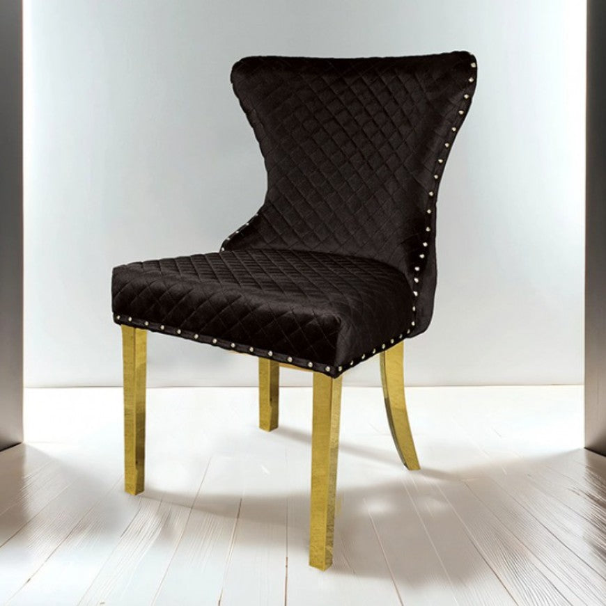 Primenova Upholstered Gold Black Dining Chair Black quilted chair with gold legs on a white floor and background